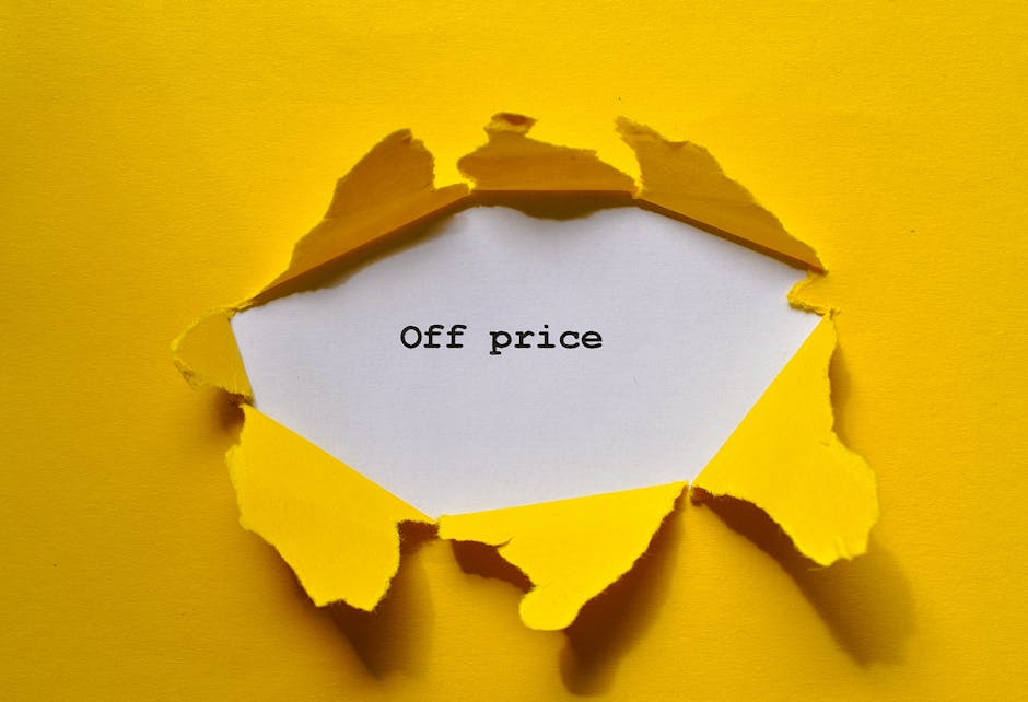 A close-up image shows a torn yellow paper revealing a white paper underneath with the words 'Off price' printed in black typewriter-style font. The torn edges of the yellow paper are irregular and curled, revealing a glimpse of the white paper background. The scene is set against a matching yellow background, creating a high contrast that draws attention to the torn paper and the message. The overall composition suggests a focus on discounted or reduced-price items, which could relate to the concept of savings in house removals and moving services provided by Man With a Van Hornsey. The lighting is even, highlighting the textured torn edges and the clarity of the printed text, making the visual suitable for accessibility and supporting content about moving logistics, cost guides, or packing offers.